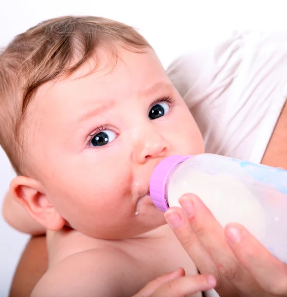 병에서 우유를 먹는 아기 스톡 이미지