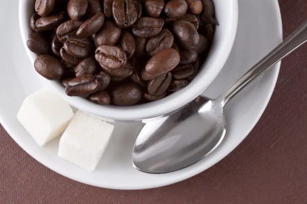 Weiße Tasse Mit Kaffeekörnern Auf Braunem Hintergrund — Stockfoto
