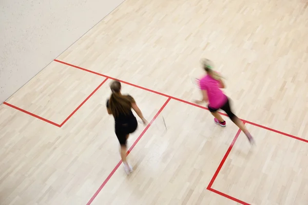 Dos jugadoras de squash en acción rápida en una cancha de squash (moti —  Fotos de Stock