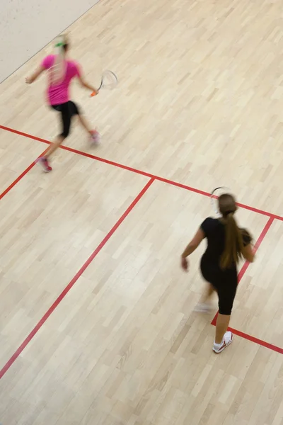 Dwóch zawodników squasha kobiet w szybkiej akcji na kort do squasha (moti — Zdjęcie stockowe