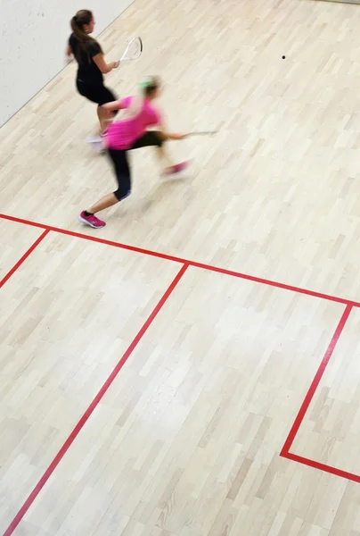 Dwóch zawodników squasha kobiet w szybkiej akcji na kort do squasha (moti — Zdjęcie stockowe