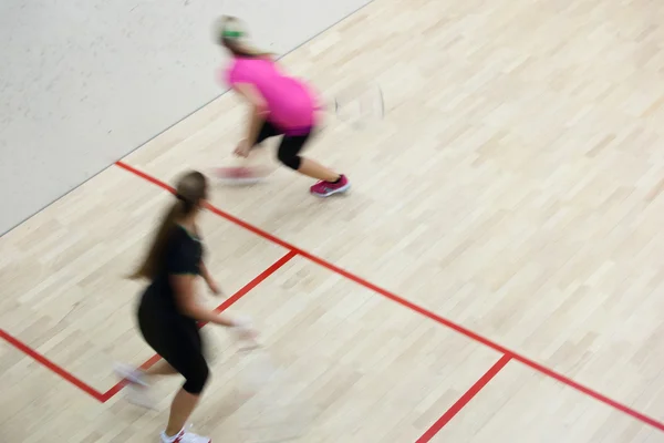 在上一个壁球 运动模糊的图像 定了调子的彩色图像的快速行动的两个女性壁球球员 — 图库照片