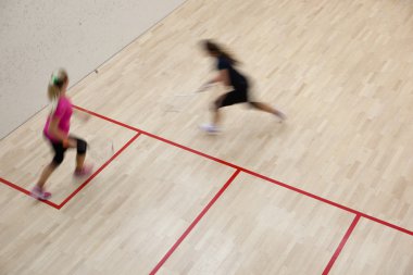 İki kadın squash oyuncular bir squash kortu (moti hızlı eylem içinde