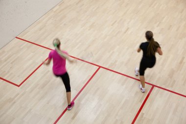 İki kadın squash oyuncular bir squash kortu (moti hızlı eylem içinde