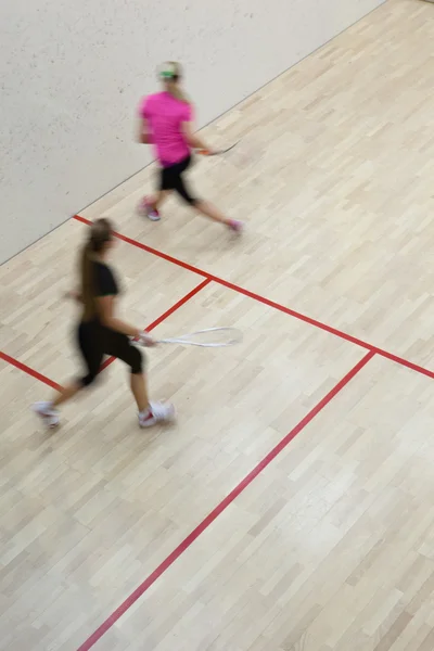 Due squash player femminili in azione veloce su un campo da squash (moti — Foto Stock