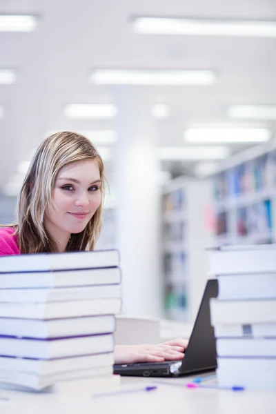 En la biblioteca - bonita, estudiante con portátil y libros wo —  Fotos de Stock