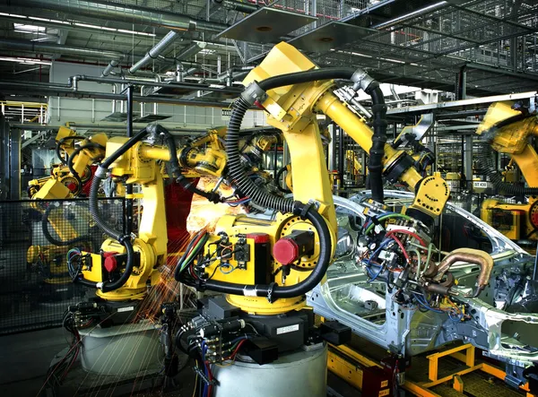 Сварочные роботы на автомобильной фабрике — стоковое фото
