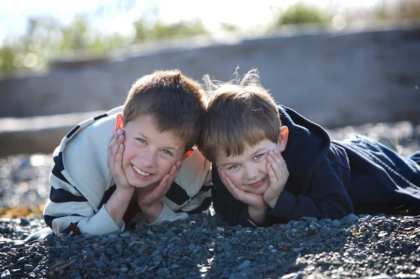 Two boys laying on a beach — Stock Photo, Image