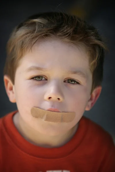 Chlapec s omítkou ústa — Stock fotografie
