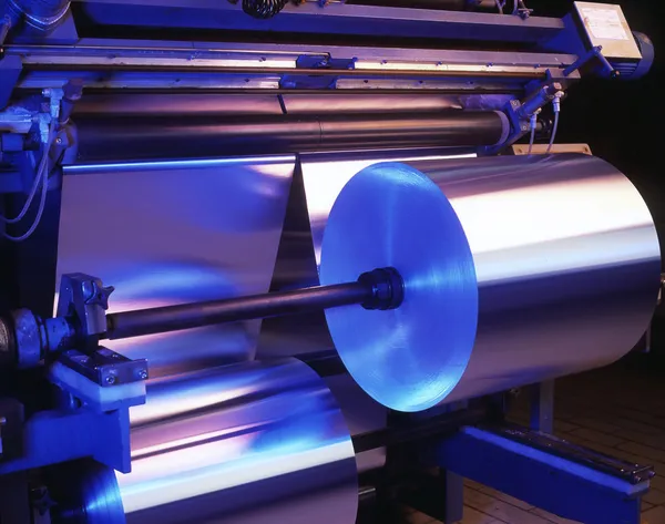 Máquina de procesamiento de papel de aluminio delgado en una fábrica Imagen de archivo