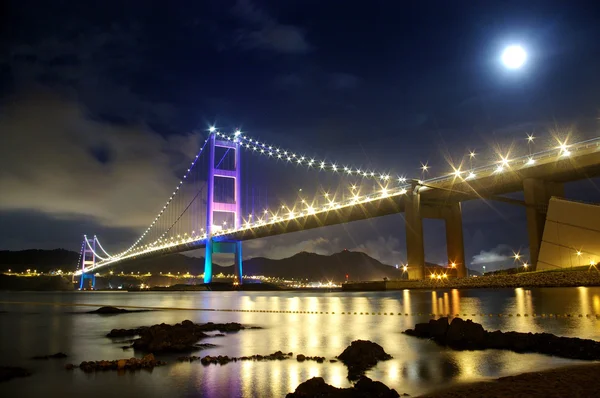 Tsing Ma Bridge Hong Kongissa yöllä, kuun kanssa — kuvapankkivalokuva