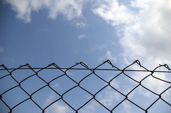Chain link fence see blue sky — Stock Photo, Image