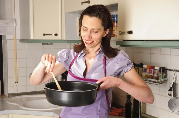 Домохозяйка на кухне с сковородкой — стоковое фото