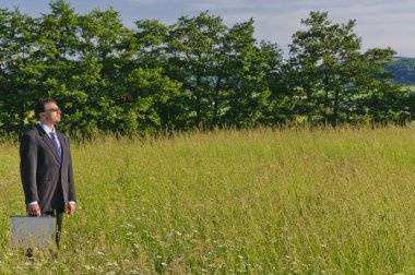 Manager standing in a meadow, looking clipart