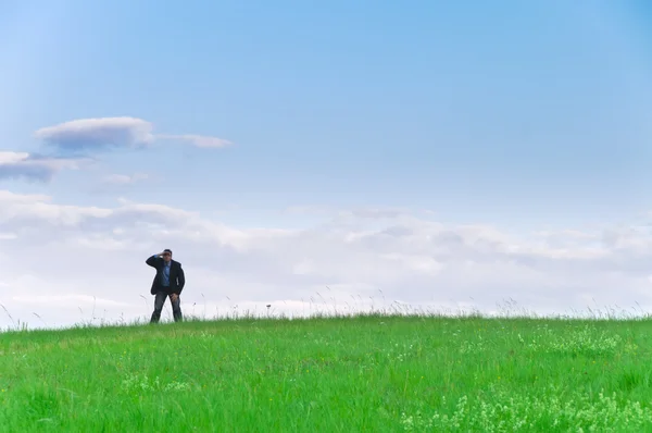 Zakenman Pak Staande Een Weide Ziet Verte Voor Wolken — Stockfoto