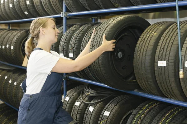 Mecânico de carro feminino com pneu — Fotografia de Stock