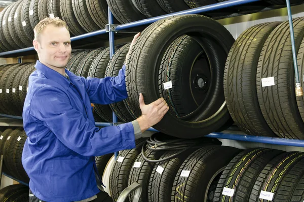 Mecânico de carro com pneu — Fotografia de Stock