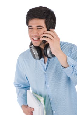 Male student calling with mobile phone holding books clipart