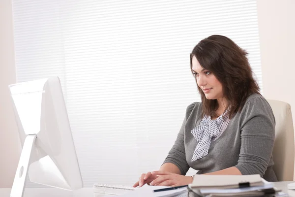 在办公室坐在桌前与计算机工作的年轻商业女人 — 图库照片