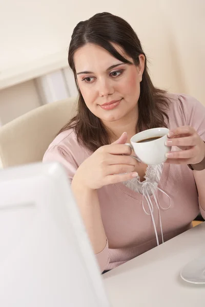 Jonge zakenvrouw genieten van koffie op moderne kantoor — Stockfoto