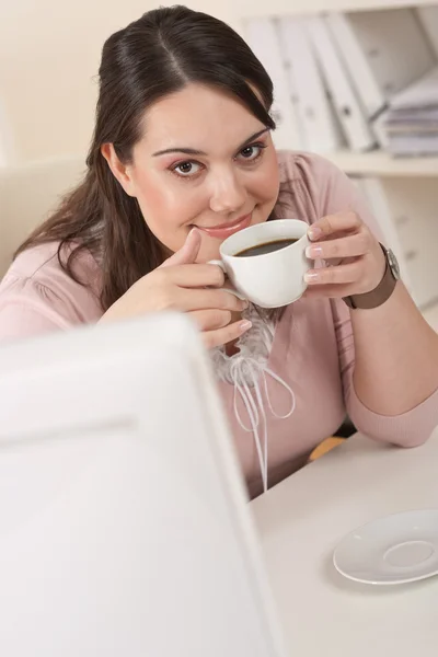 Счастливая деловая женщина делает перерыв на кофе в офисе — стоковое фото