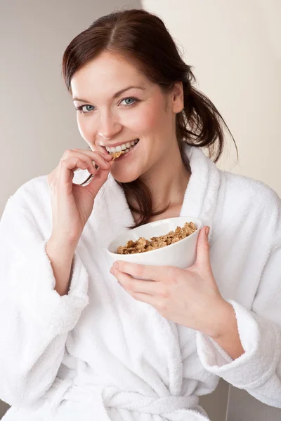 Woman in bathrobe holding bowl with cereals for breakfast — Stock Photo, Image