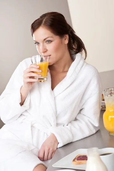 モダンなキッチンにオレンジ ジュースと朝食を楽しんで若い女性 — ストック写真