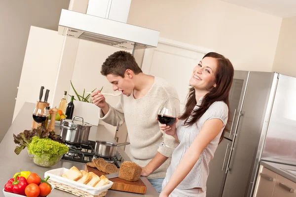 若いカップルが一緒に赤ワインを飲むの台所で調理 — ストック写真