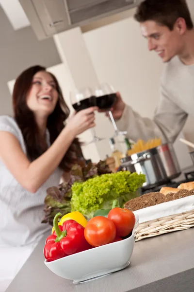 Giovane coppia che beve vino rosso in cucina — Foto Stock