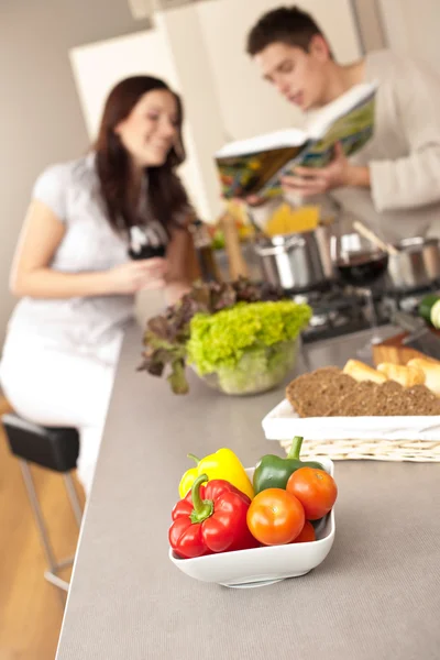 Пара на кухне выбирая рецепт из поваренной книги — стоковое фото