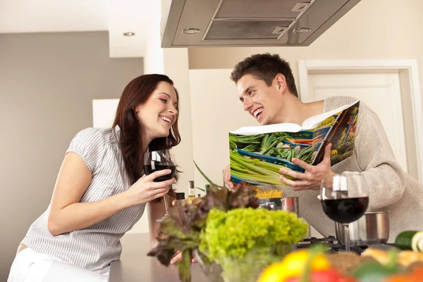 对年轻夫妇在厨房选择食谱食谱喝红酒 — 图库照片