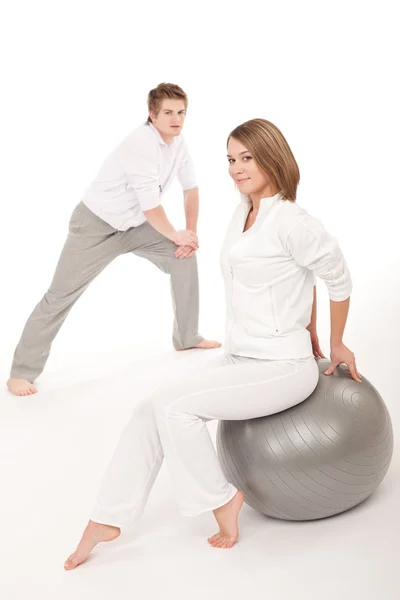 Fitness - zdravé pár táhnoucí se po tréninku na bílém pozadí — Stock fotografie