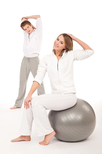 Fitness - friska par stretching efter träning på vit — Stockfoto