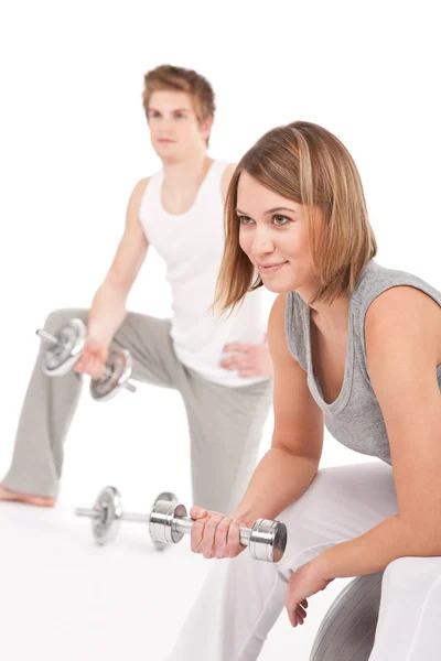 Young couple with weights and fitness ball on white — Stock Photo, Image