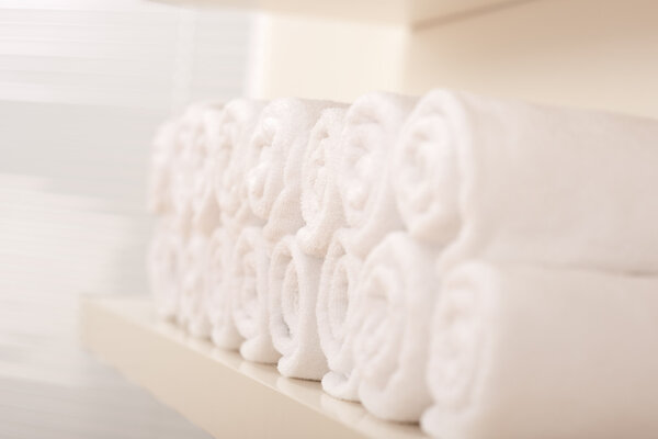 Line of rolled up white bath towels