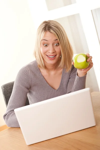 金发碧眼的学生使用的笔记本电脑和吃苹果 — 图库照片