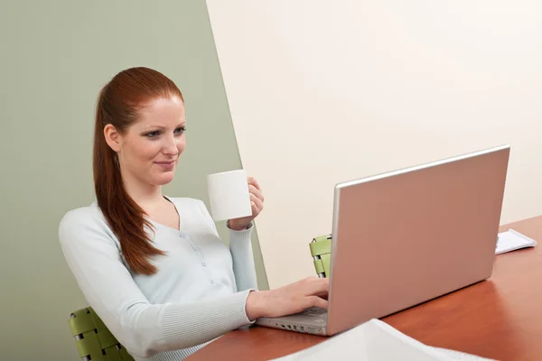 Frau mit langen roten Haaren im Büro mit Kaffee — Stockfoto