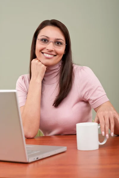 Usmívající se sekretářka s kávou a přenosný počítač v kanceláři — Stock fotografie