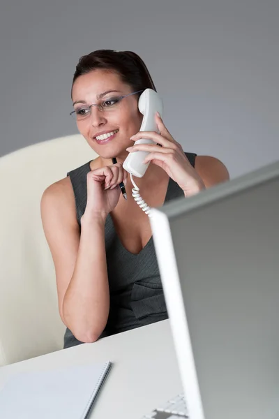 Kobieta rozmawia przez telefon w urzędzie — Zdjęcie stockowe