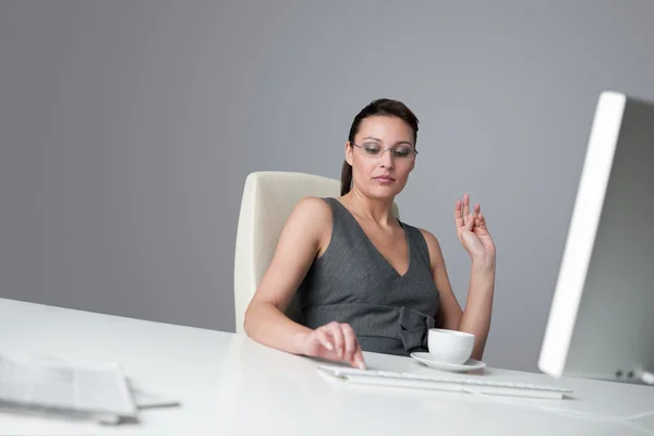 成功的业务在办公室喝杯咖啡坐在电脑桌前的女人 — 图库照片