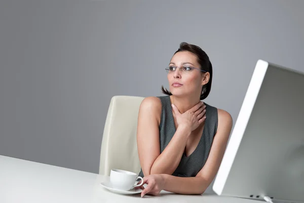 Задумчивая деловая женщина в офисе с кофе — стоковое фото