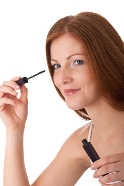微笑的红头发女人在白色背景上应用睫毛膏 — 图库照片