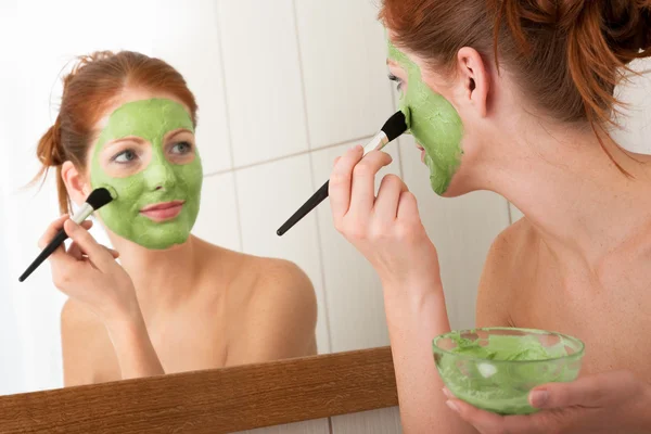 Série de cuidados com o corpo - Mulher jovem aplicando máscara facial — Fotografia de Stock