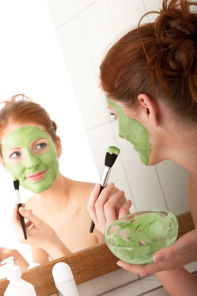 Jovem Aplicando Máscara Facial Verde Banheiro — Fotografia de Stock