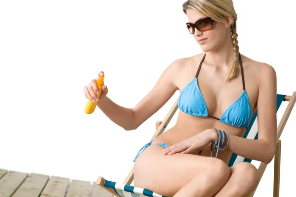 Strand - junge Frau im Bikini trägt Sonnencreme auf — Stockfoto