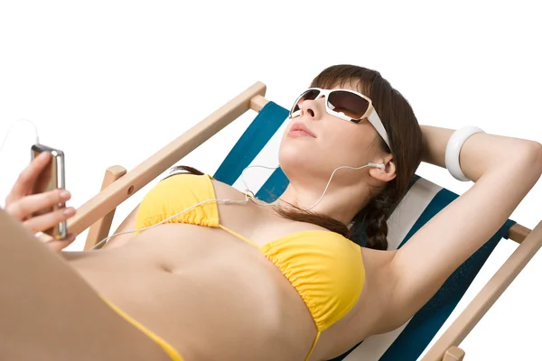 Strand - vrouw luisteren naar muziek in bikini zonnebaden — Stockfoto