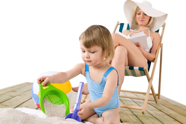 ビーチ - 砂のおもちゃで遊ぶ子供を持つ母 — ストック写真