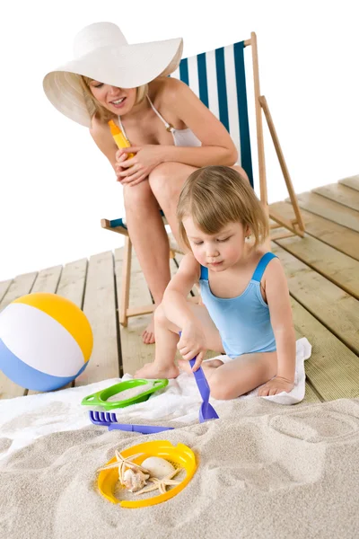 Παραλία - μητέρα με παιδί που παίζει με τα παιχνίδια στην άμμο — Φωτογραφία Αρχείου