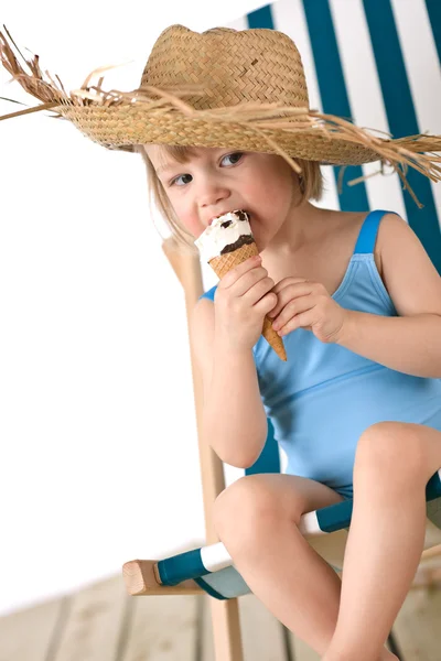 Stock image Beach - Little girl on deck-chair with straw hat and ice-cream cone