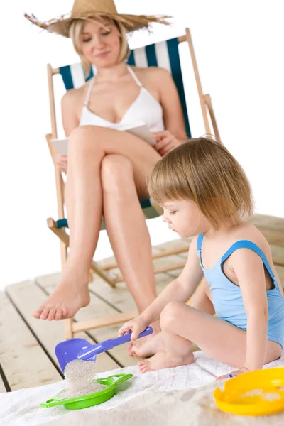 Пляж - Мать с ребенком играют с игрушками на песке — стоковое фото